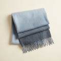 Nadia gradient blanket scarf shading dusty blue to slate, folded on a cream studio backdrop