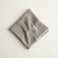 Valentina houndstooth square scarf in charcoal and cream, folded on a cream studio backdrop